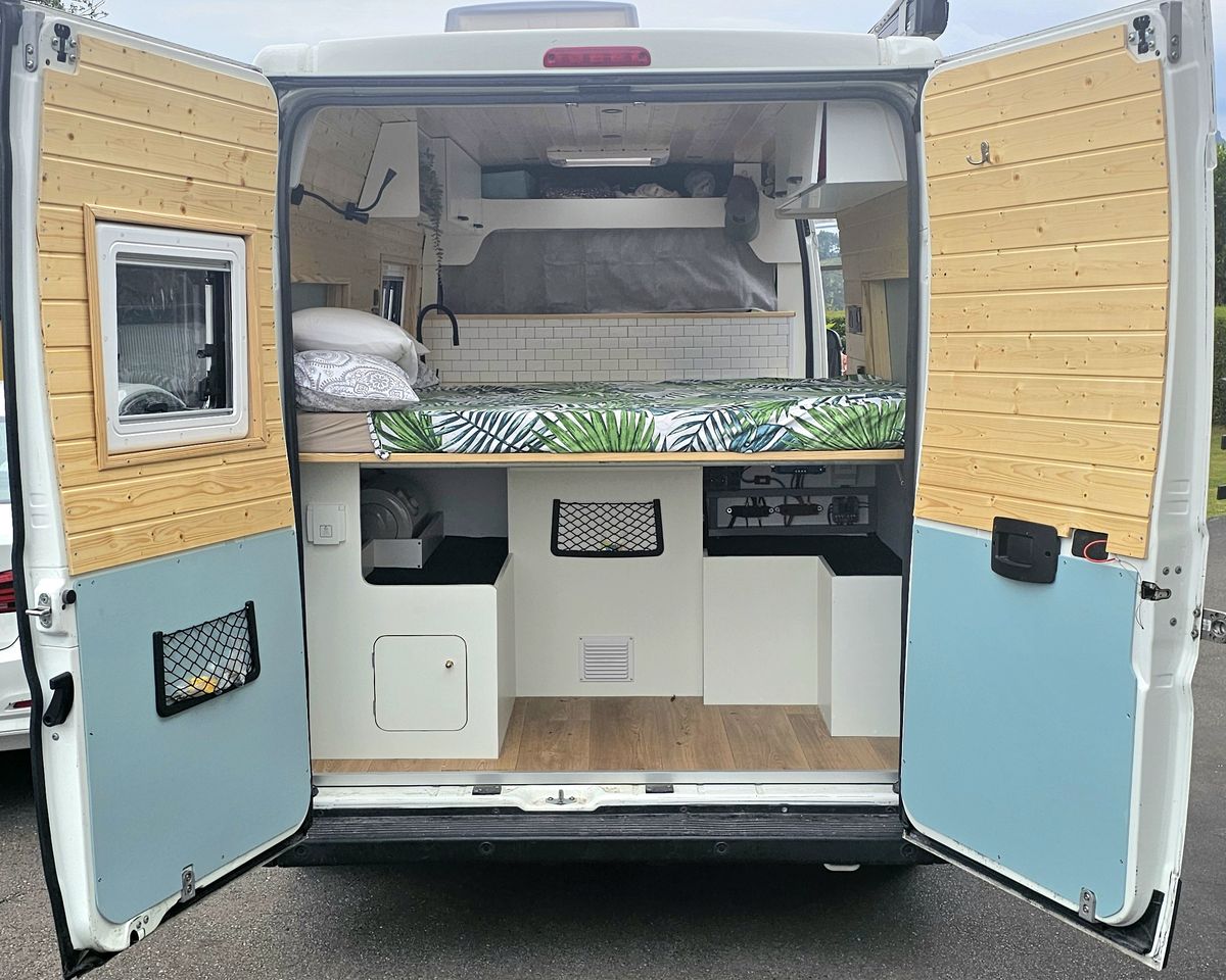 Vista trasera de la camper con cama y almacenaje