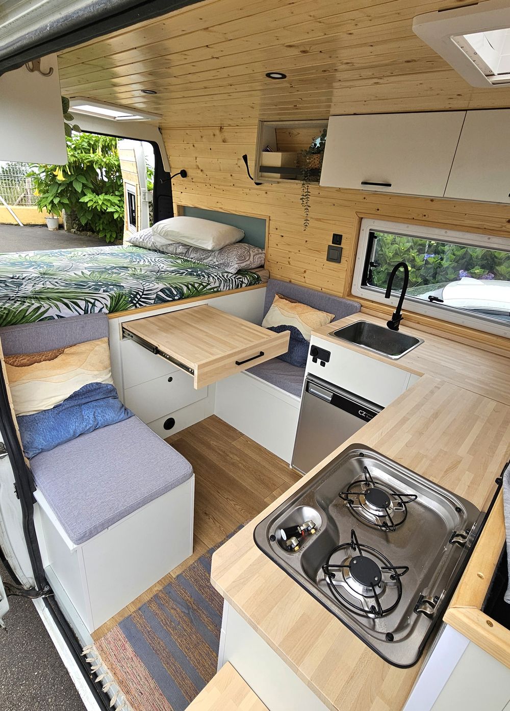 Cocina con fogones y salón con mesa abatible
